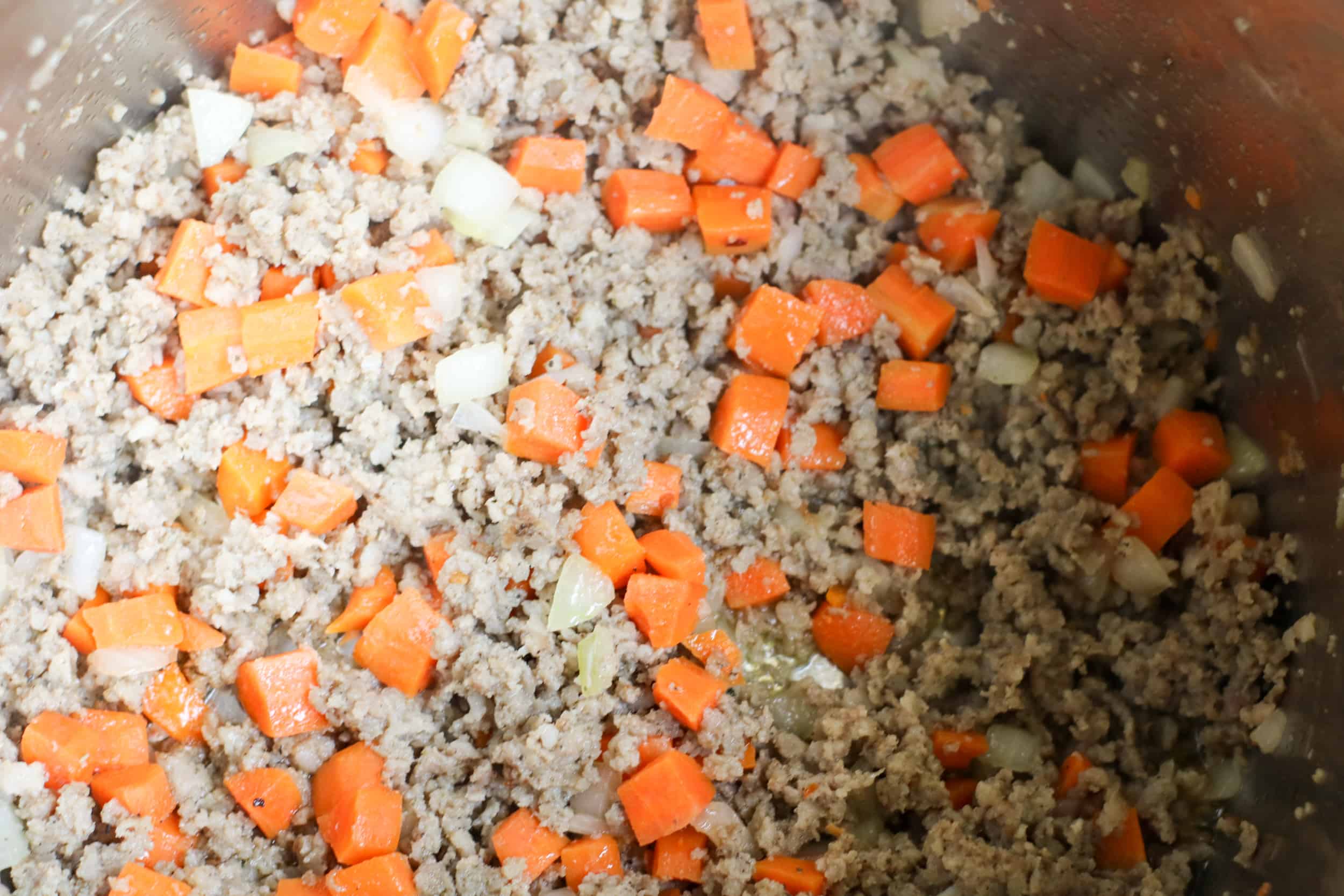 ground sausage, carrots and onions in pot