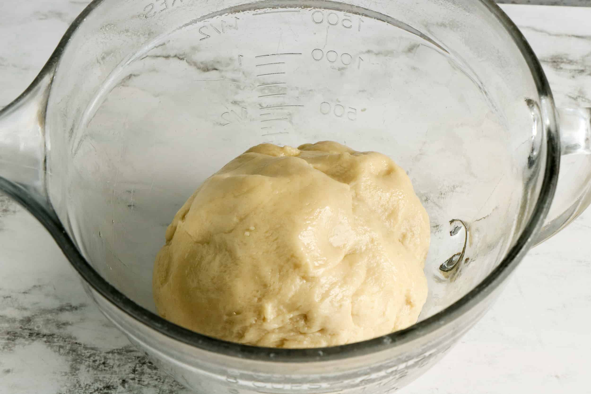 dough rising in glass bowl