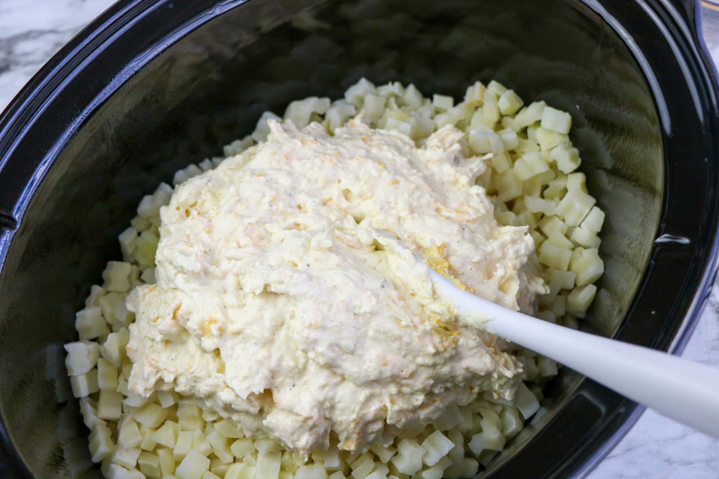 hashbrowns and cheese sauce in slow cooker