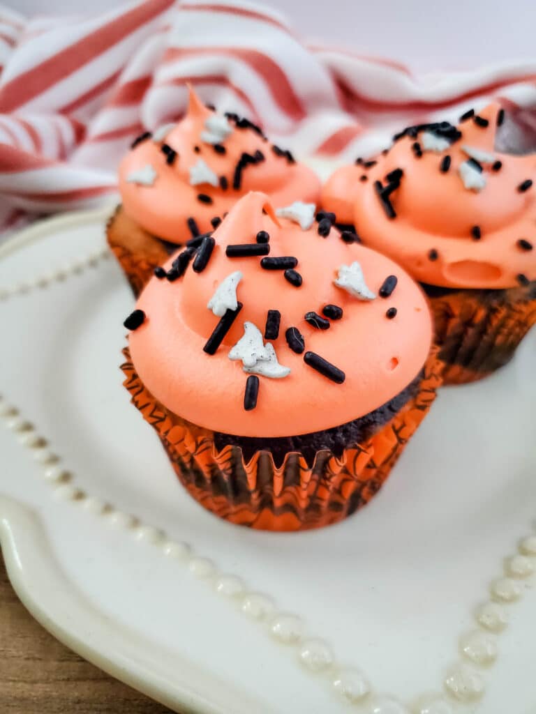 Close up vertical image of Halloween Tie Dye Cupcakes on a white plate