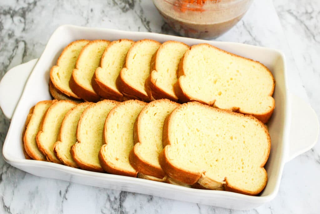 sliced of bread layered in a baking dish