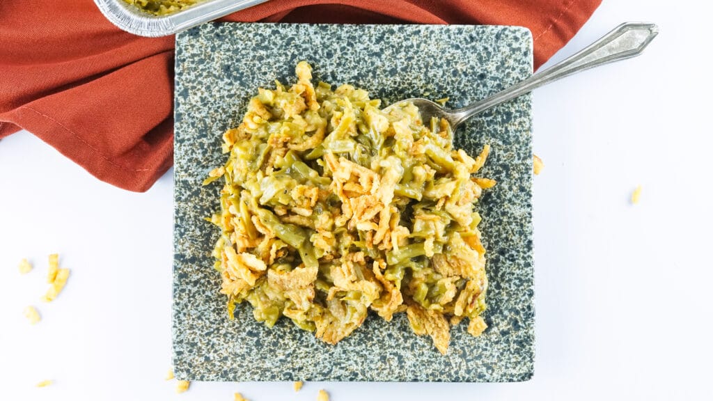birds eye image of smoked green bean casserole on a black and white marble plate with a spoon