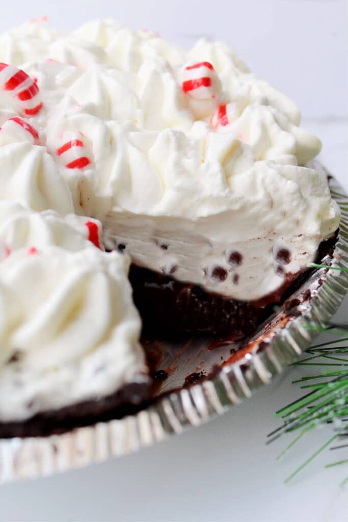 Off center image of candy cane pie with a slice cut out of it.