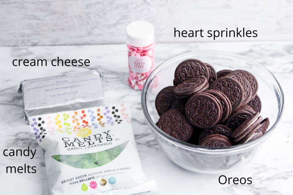 Ingredients needed to make Grinch Oreo Balls on a marble counter top