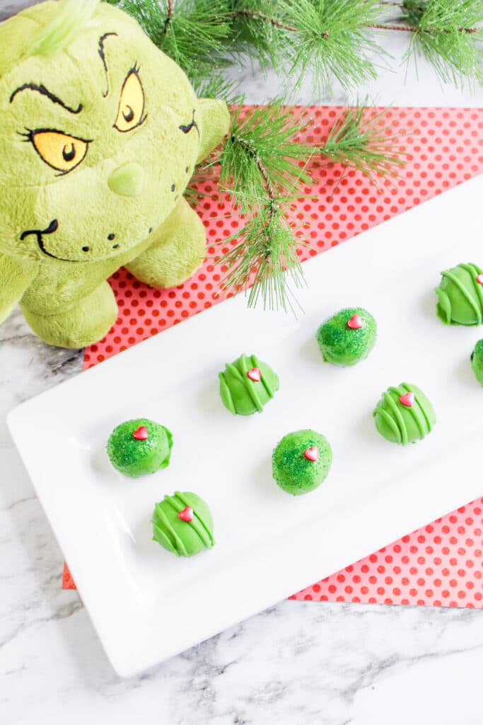 Birds Eye image of grinch oreo balls with a stuffed grinch in the background