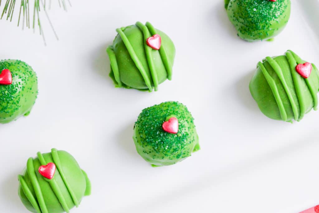 close up image of six grinch oreo balls on a white platter