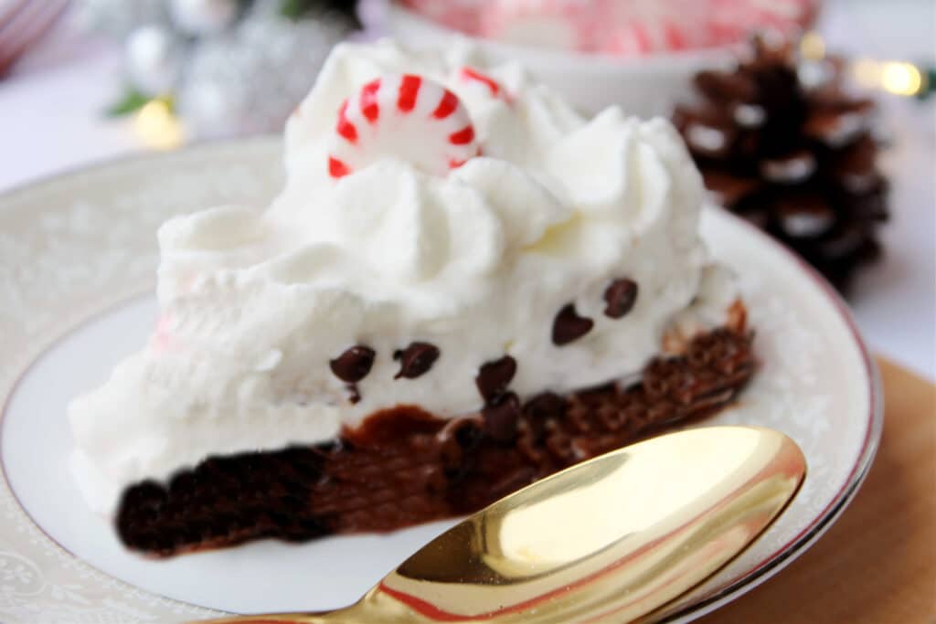 side view of a slice of Candy Cane Pie slice on a plate with a gold spoon