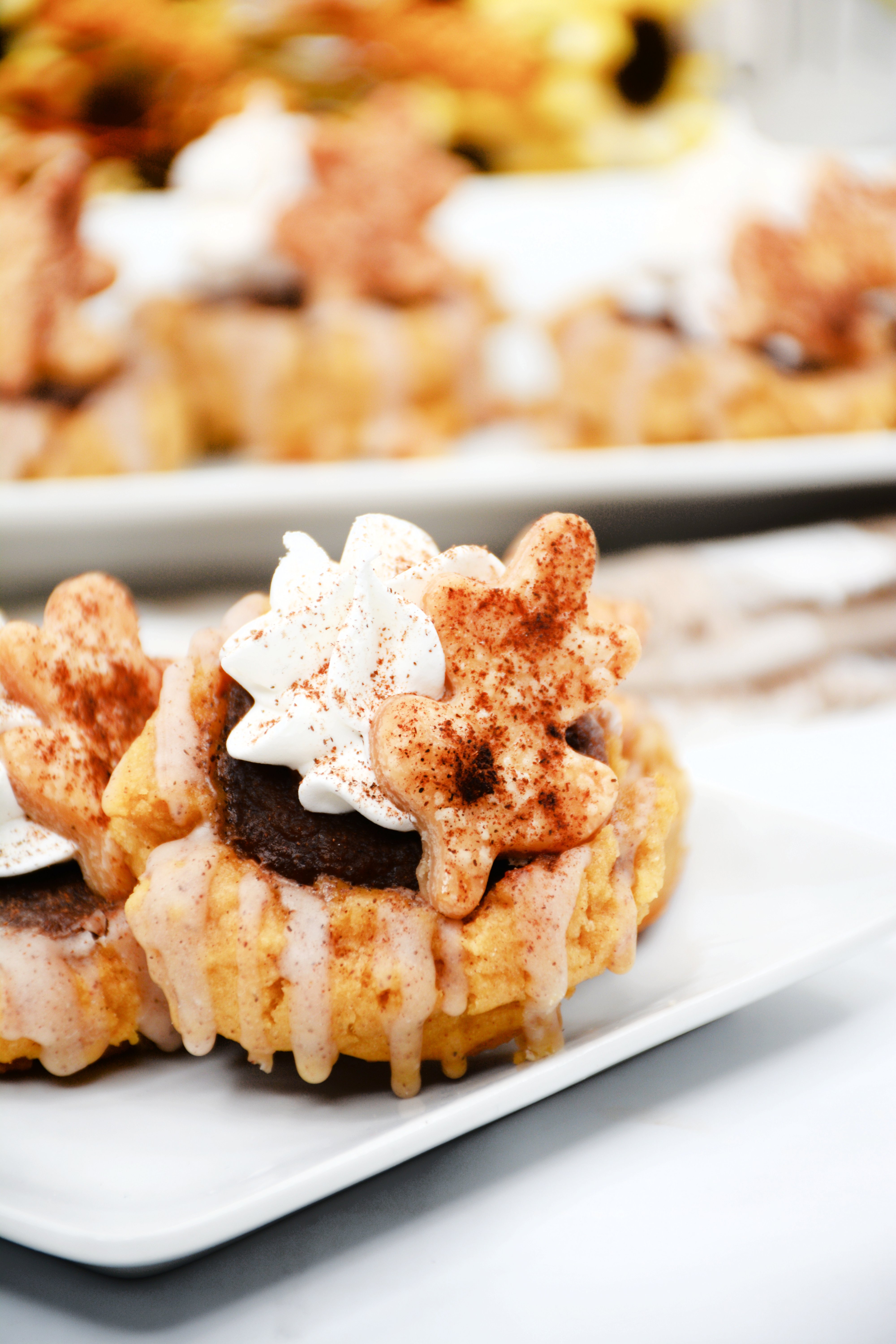 Side view of two pumpkin pie cookies on a white plate