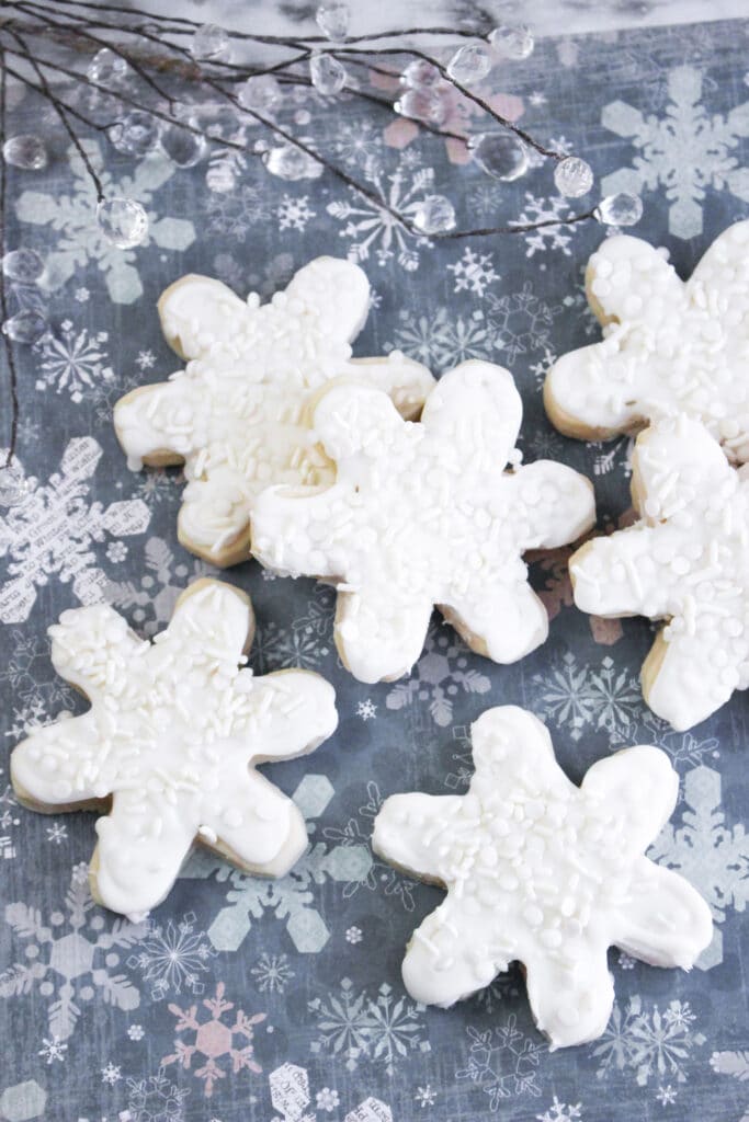 six snowflake cookies on a blue and white snowflake background