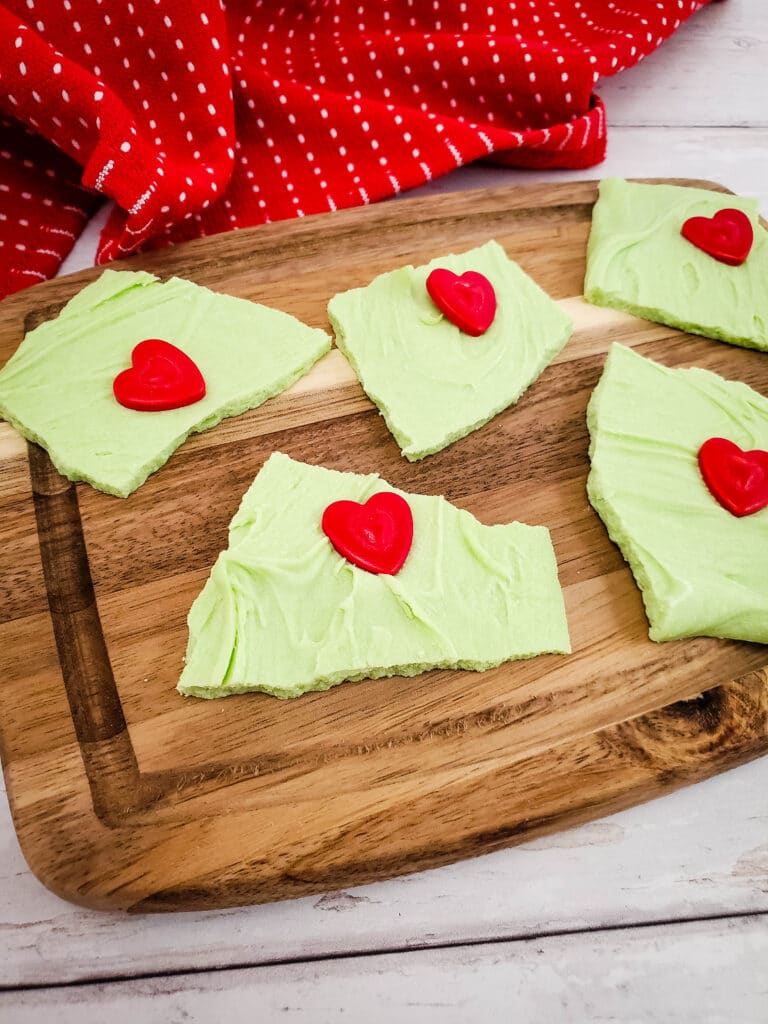 Grinch Bark on a wooden cutting board with a red and white napkin in the background
