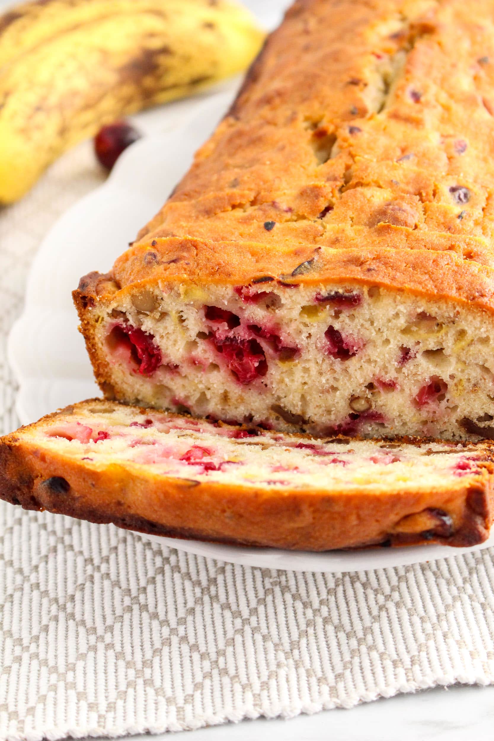 Cranberry Banana Bread on a white plate with a tan napkin