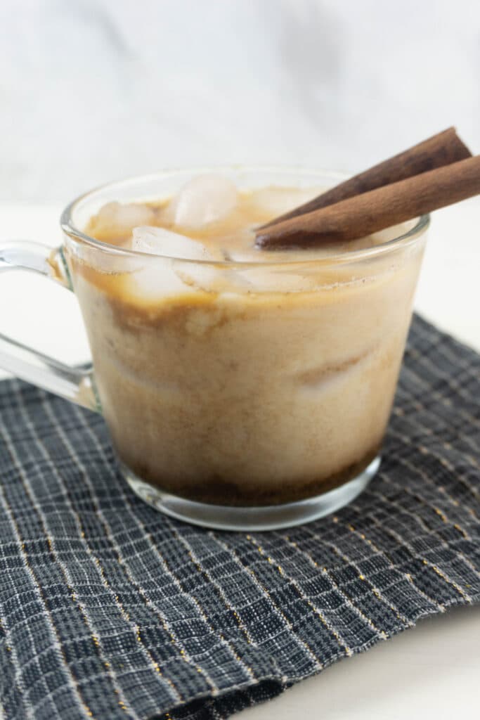 vertical side view image of a gingerbread white russian in a clear mug