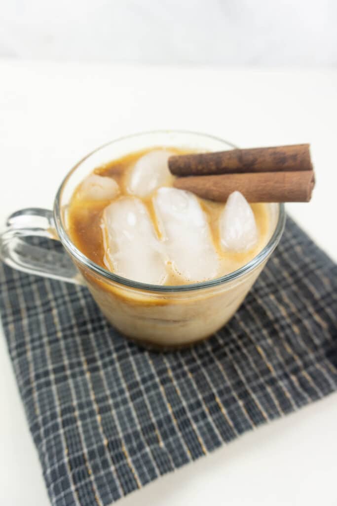 birds eye image of a clear mug filled with gingerbread white russian with cinnamon sticks