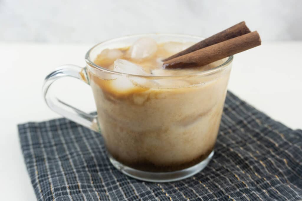 side view of a clear glass mug filled with gingerbread white russian in a glass mug