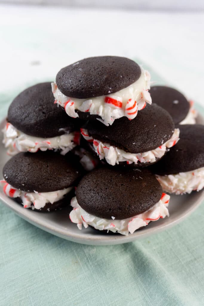 vertical image of peppermint whoopie pies on a green napkin