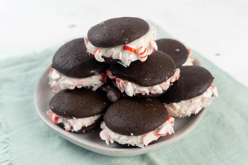 Side view image of peppermint whoopie pies on an off white plate