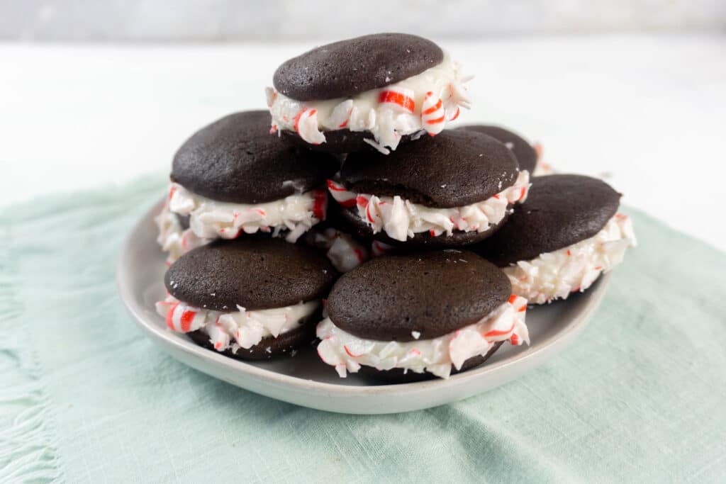 close up horizontal image of peppermint whoopie pies on an off white plate