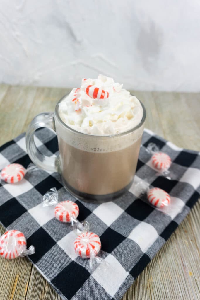 espresso peppermint hot chocolate in a clear glass mug and topped with a peppermint