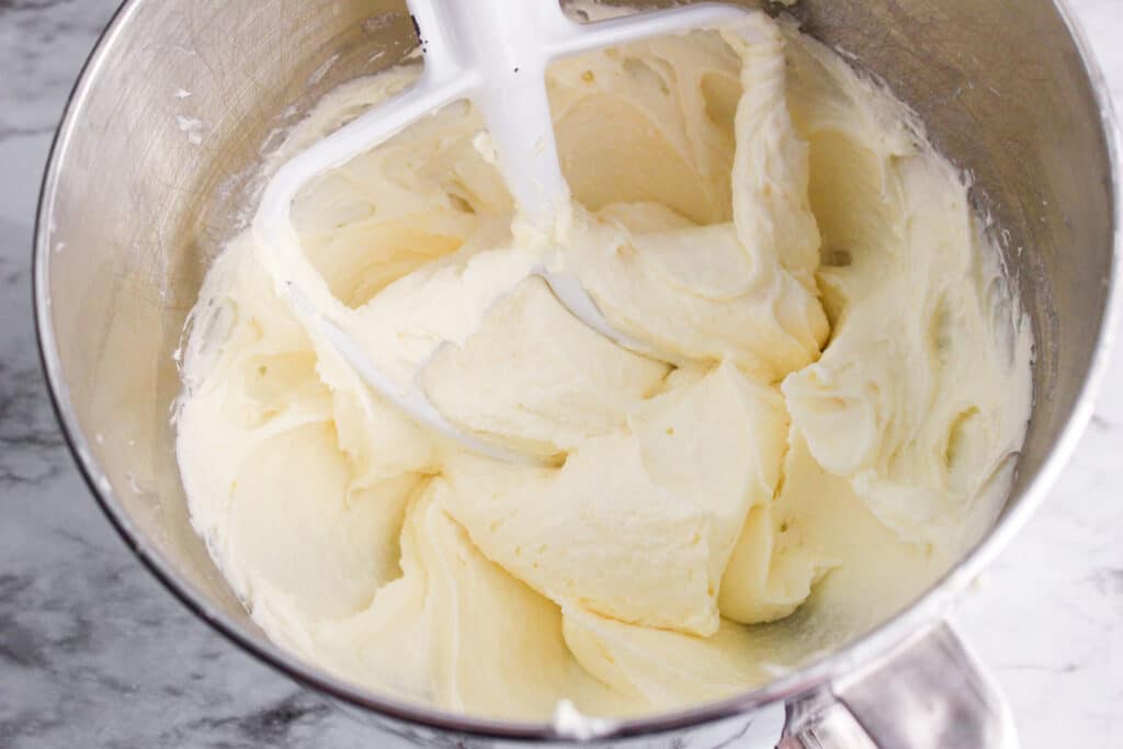 butter, sugar, and cream cheese being creamed in stand mixer