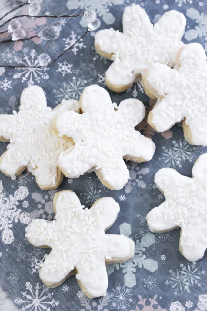 vertical image of snowflake chistmas cookies on a snowflake backdrop