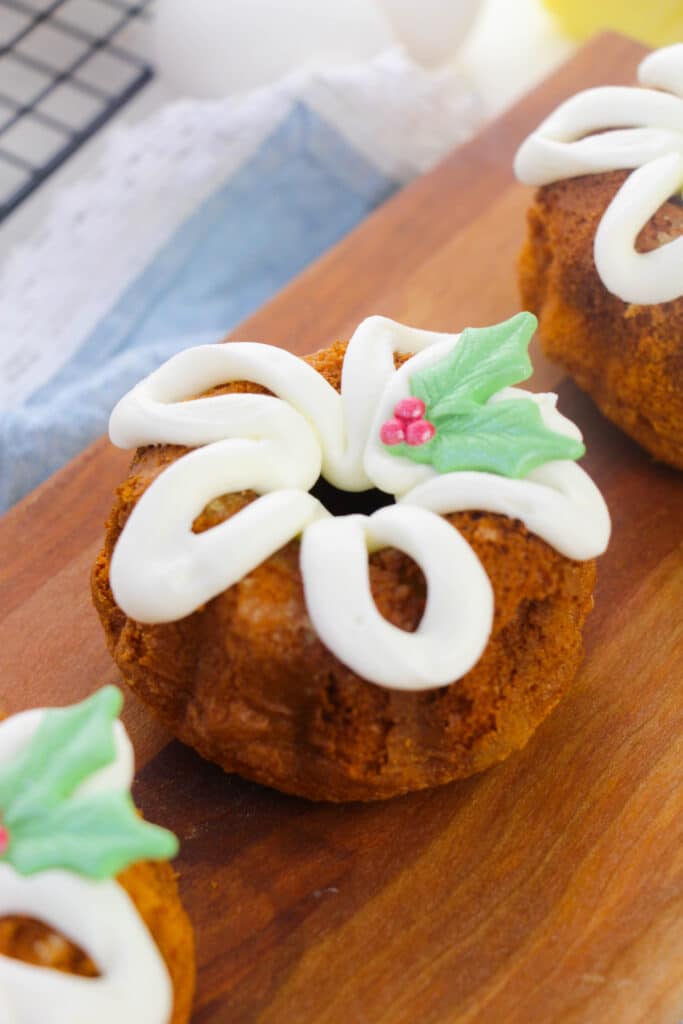 Vertical image of mini bundt cake on a wooden cutting board