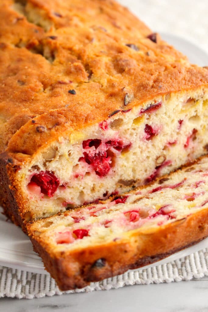 vertical image of Loaf of Cranberry Banana Bread that has been sliced