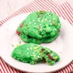 close up square image of three grinch cake mix cookies on a white plate