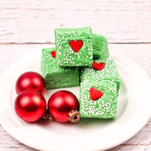 square image of grinch fudge on a white plate with red ornaments