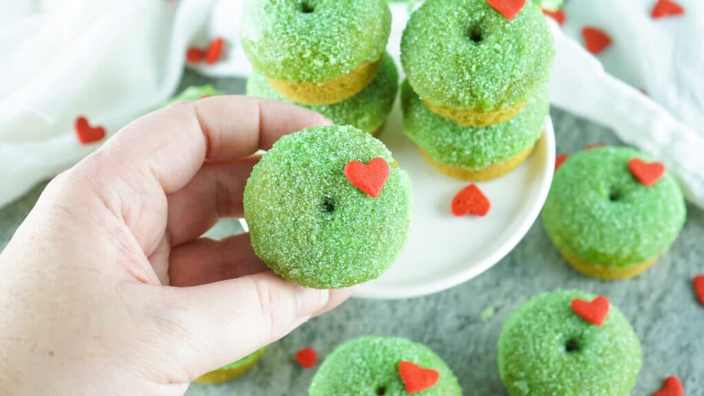 vertical image of grinch donuts on a white plate