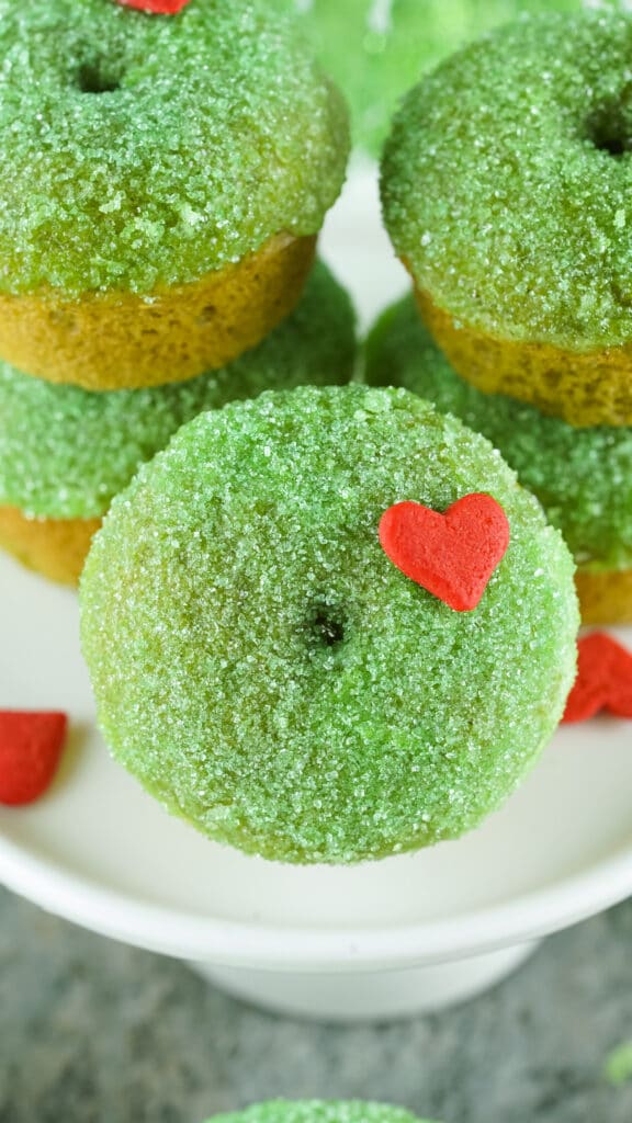 close up image of a grinch donut with a red candy heart