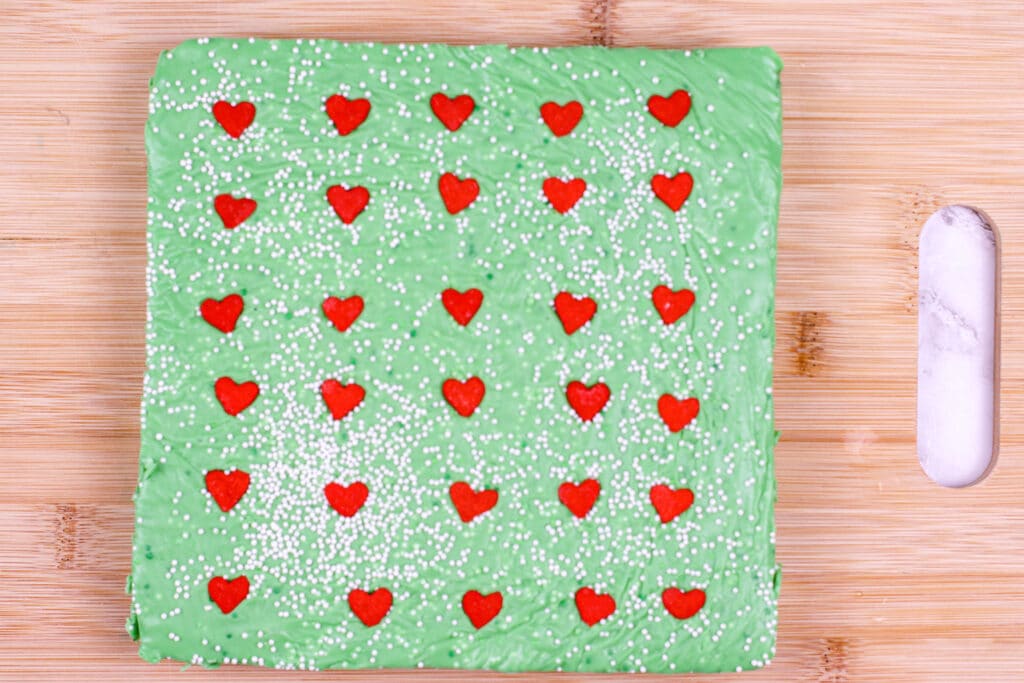 Grinch Fudge on a wooden cutting board ready to be cut