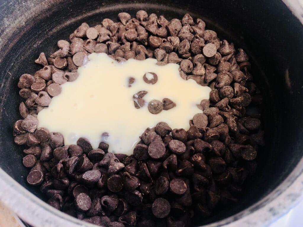 chocolate chips with sweetened condensed milk in a saucepan