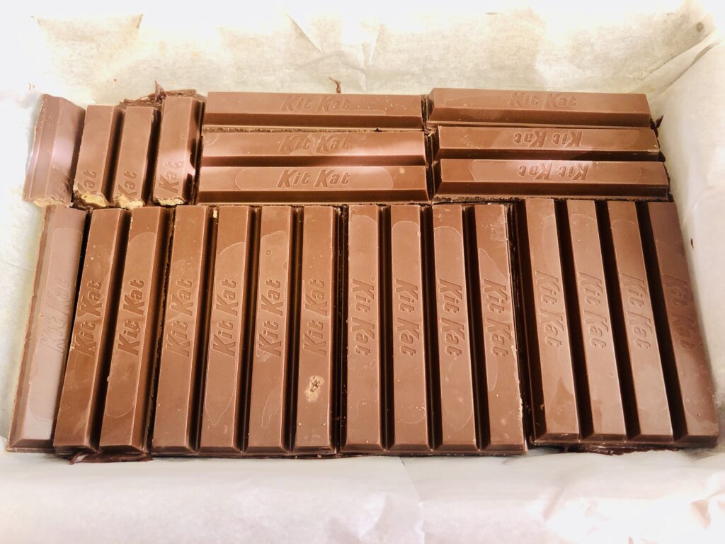 Kit Kats laid out in a row in a square baking pan