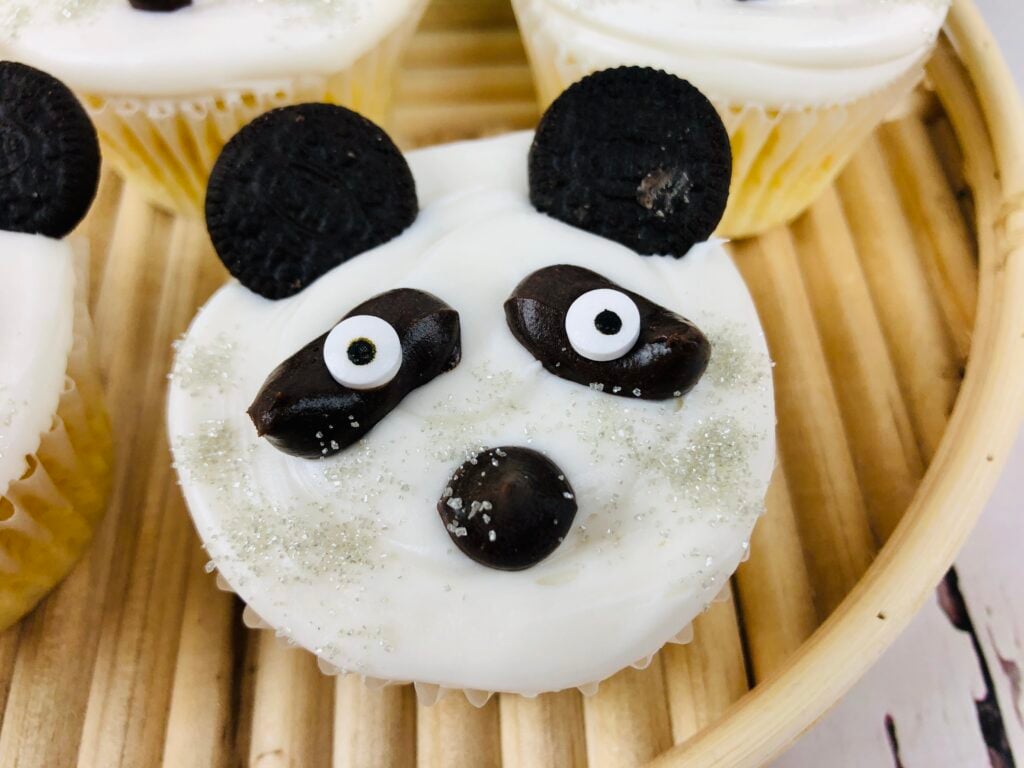 close up of a single panda cupcake on a bamboo serving tray