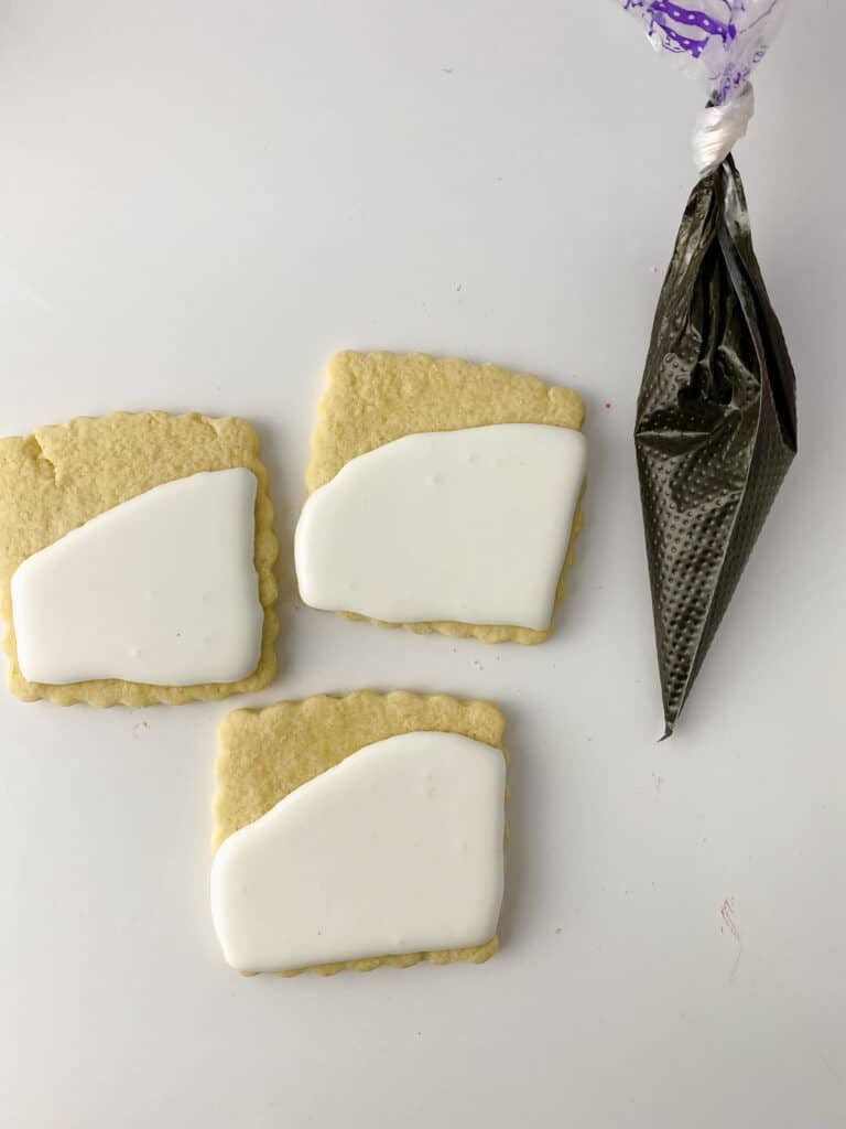 square sugar cookies topped with white royal icing