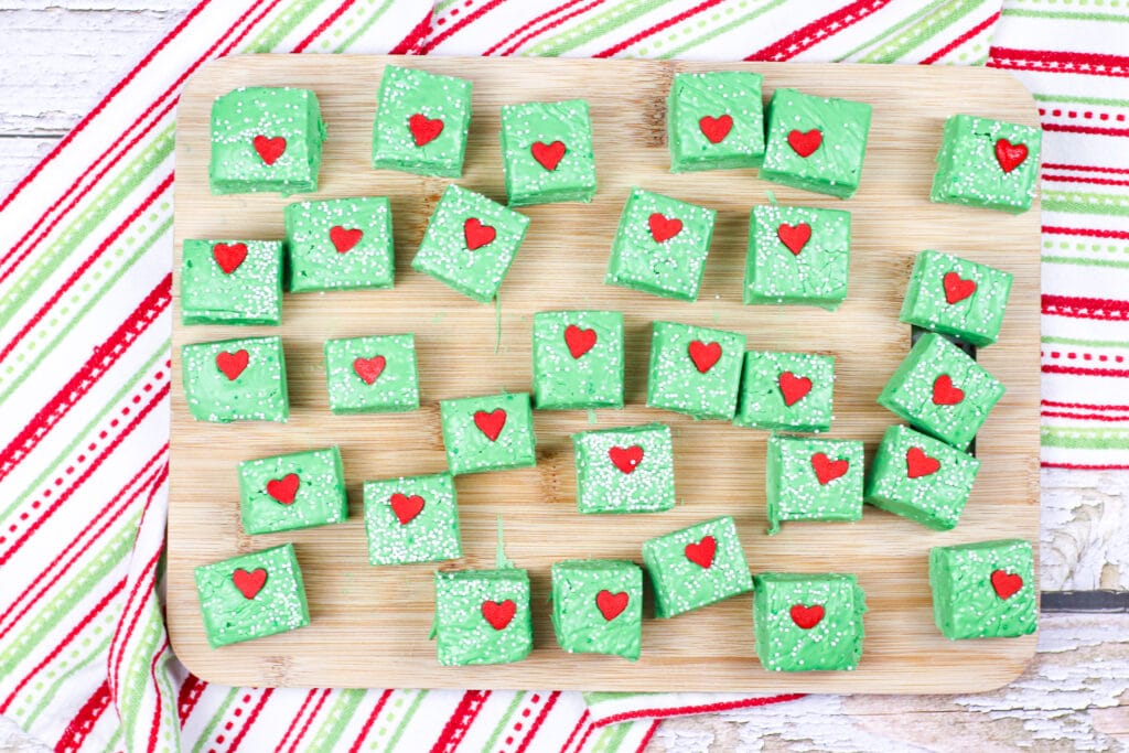 Grinch Fudge cut into squares on a wooden cutting board