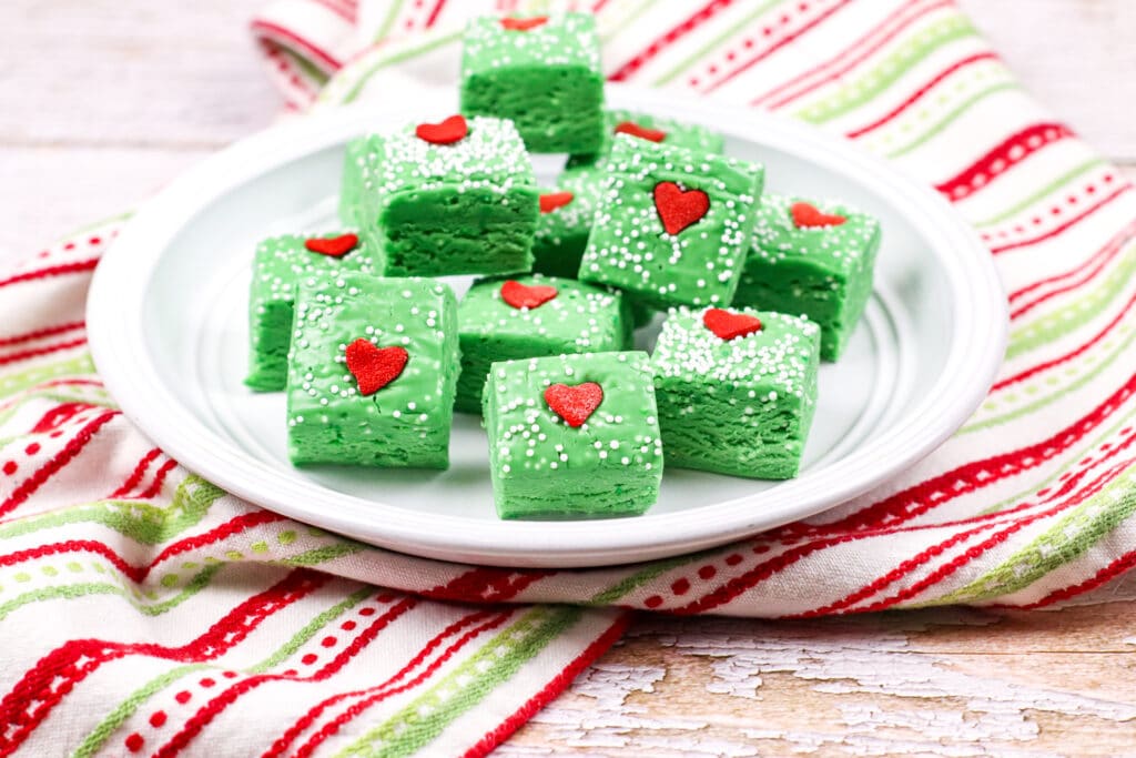 Grinch fudge stacked in a semi-pyramid on a white ceramic plate
