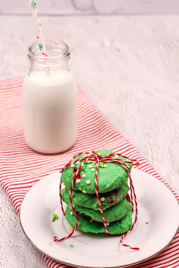 Stack of Grinch Cake Mix Cookies tied with a red and white ribbon