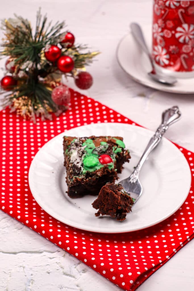 grinch brownie on a small white plate with a bite missing