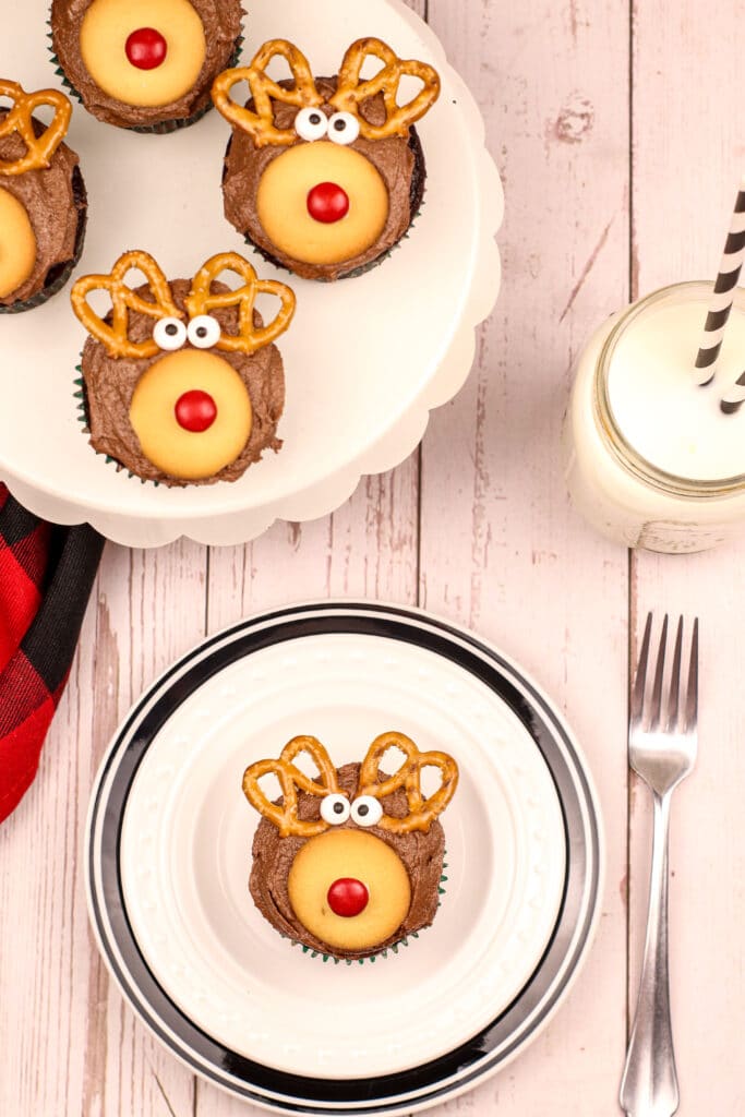 rudolph cupcake with a red nose on a white and black plate