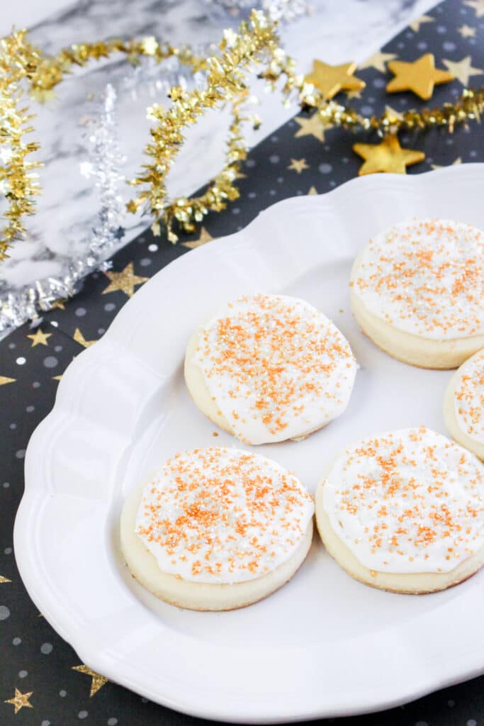 off center vertical imge of five new years eve sugar cookies on a white platter