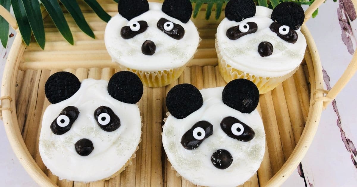 rectangle image of four panda cupcakes on a bamboo tray