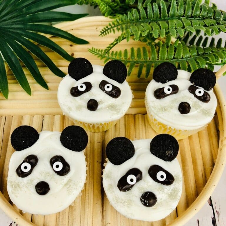 square image of four panda cupcakes on a bamboo tray