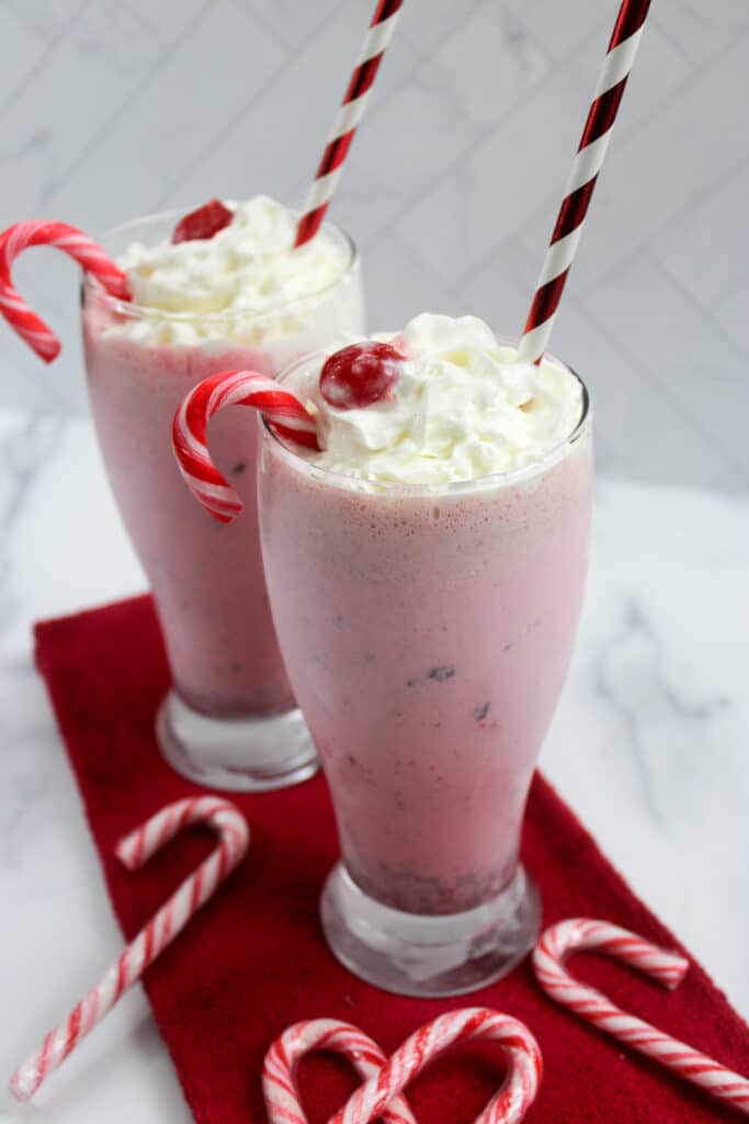two glasses of peppermint milkshakes on a red napkin