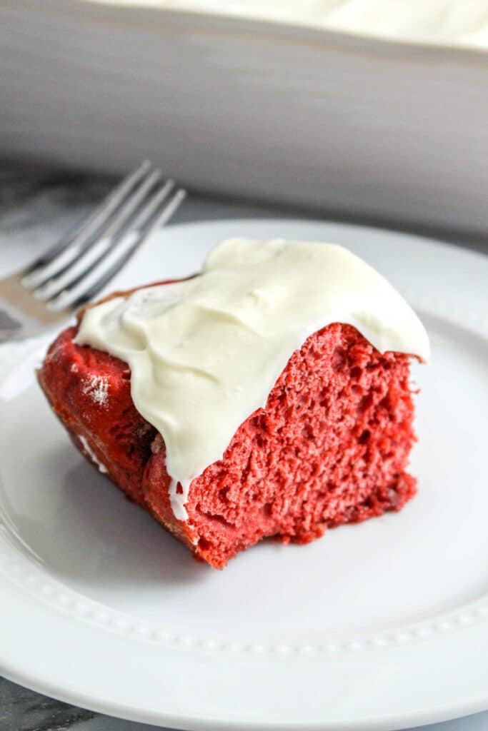 red velvet cinnamon rolls on a white plate with cream cheese frosting