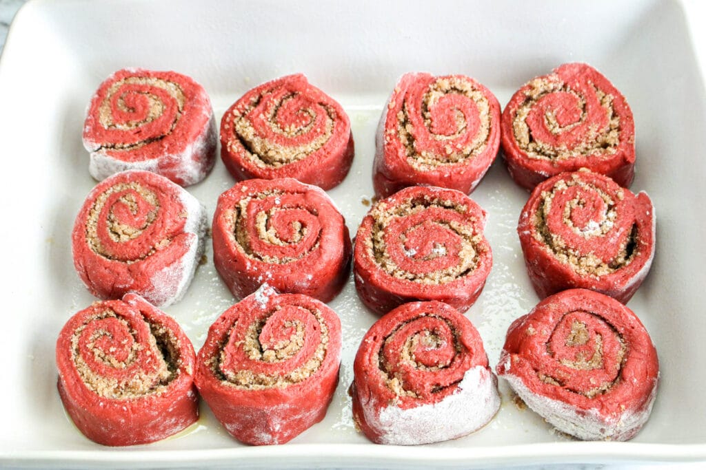 red velvet cinnamon rolls in a white baking dish