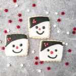square image of three snowman face cookies topped with royal icing