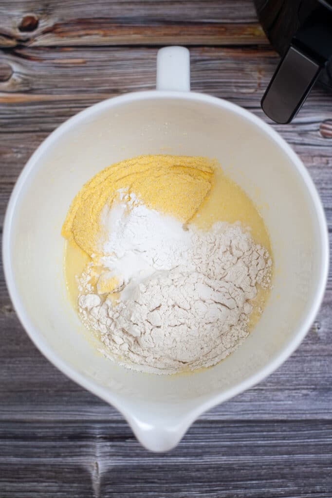 flour, cornmeal and melted butter in a white mixing bowl
