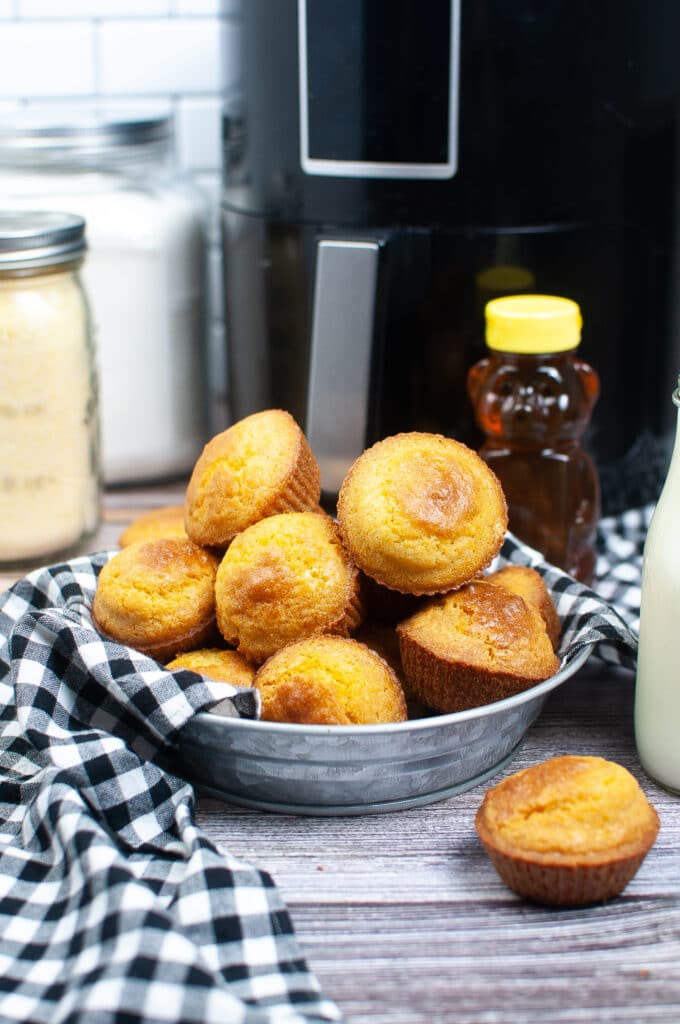 Vertical image of cornbread muffins in a stainless steel platter