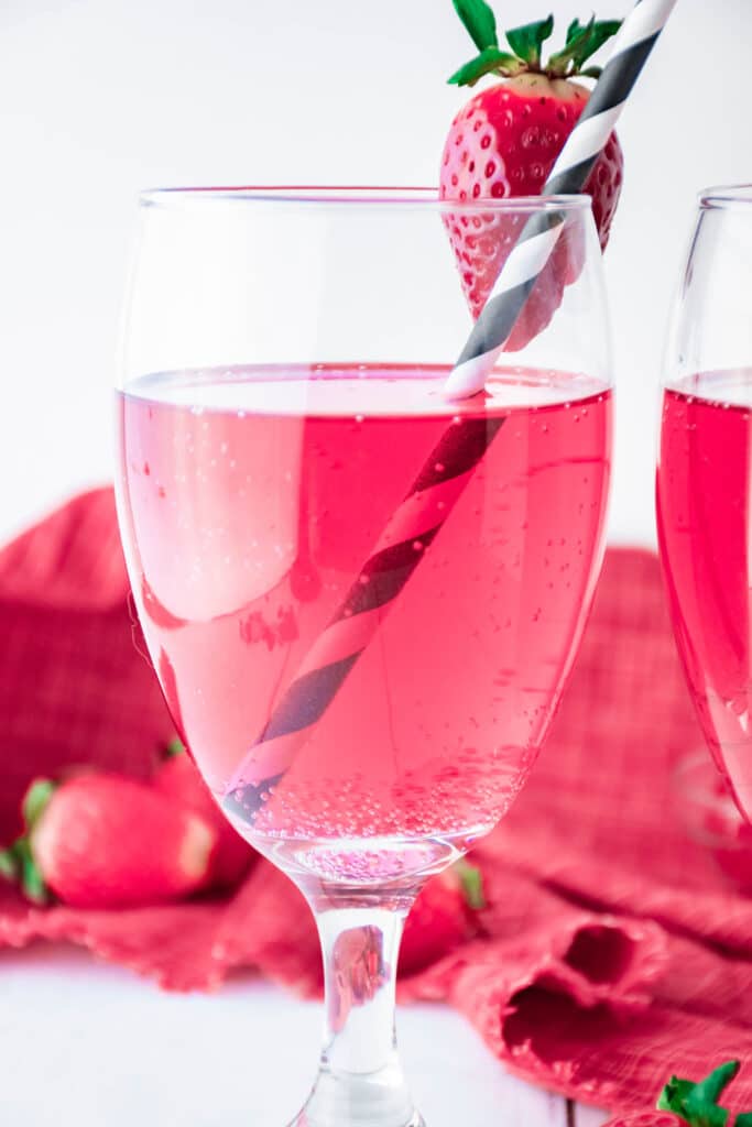 Cupid's Cocktail in a wine glass with a strawberry on the rim